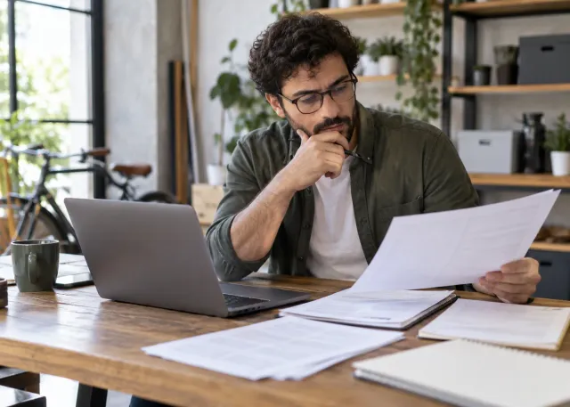 A careful employee reviews an AI-assisted draft against source documents before sharing a customer-facing answer; human responsibility is visibly central.